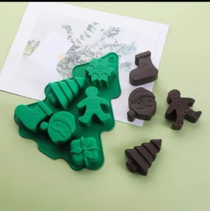 Molde de silicona verde con formas navideñas: árbol, copo de nieve, Santa, galleta, regalo y bota.