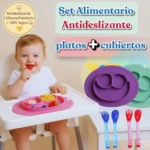 Bebé sonriente en trona con plato de silicona rosa y cubiertos. Set alimentario antideslizante.