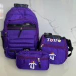 Set escolar Totto morado: morral grande, lonchera y estuche pequeño con logo blanco y detalles en rojo y amarillo.