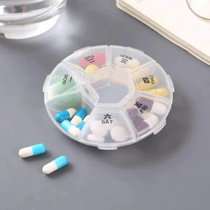 Pastillero organizador redondo transparente con compartimentos para 7 días, lleno de pastillas y cápsulas de colores.