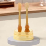 Cepillo de silicona para bebé, 2 unidades en soporte transparente. Uno con cerdas, otro con relieve.