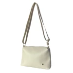 Bolso cruzado tipo bandolera, color beige claro, piel sintética lisa, colgando con correa ajustable y herrajes dorados.