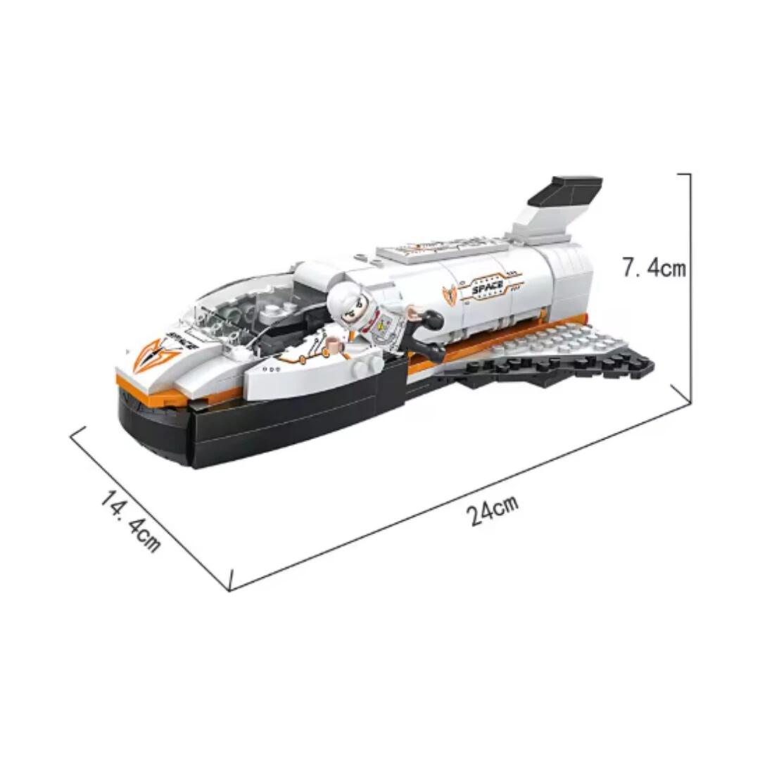 Nave espacial blanca con detalles naranjas, astronauta y medidas 24x14.4x7.4 cm.