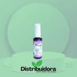 Tónico capilar de aguacate en spray con etiqueta floral violeta, presentado en un escenario verde.