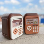 Set de dos alcancías electrónicas Labubu con teclado numérico, una blanca y otra terracota, sobre superficie rugosa con cielo azul de fondo.