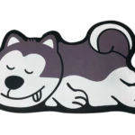 Tapete decorativo antideslizante con diseño de perro husky dormido, color morado y blanco.