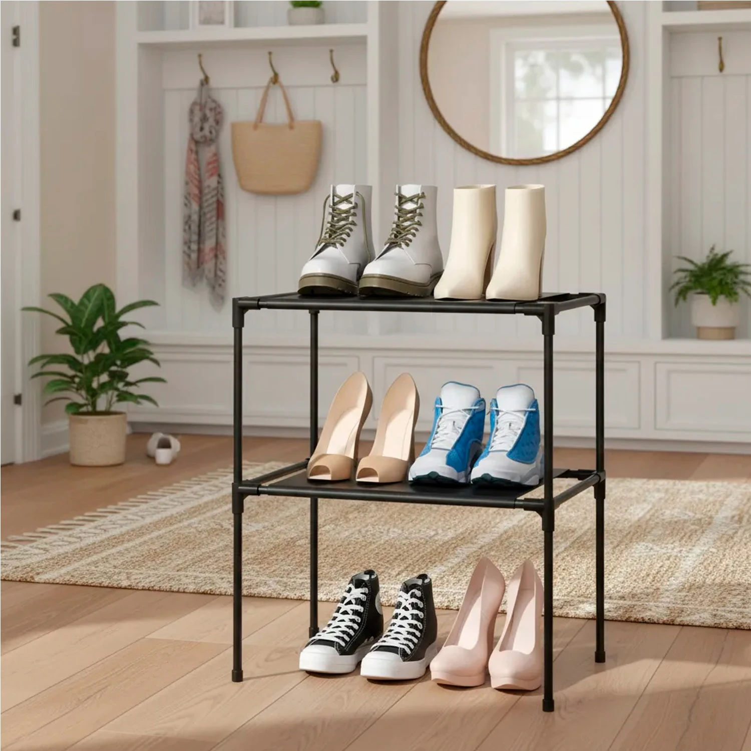 Organizador de zapatos negro de 3 niveles con botas blancas, botines crema, zapatillas deportivas y tacones.