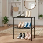 Estante negro de 3 niveles con 9 pares de zapatos: botines, zapatillas y tacones.