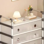 Zapatero de 7 niveles gris con cubiertas translúcidas, lámpara y flores decorativas en la repisa superior.