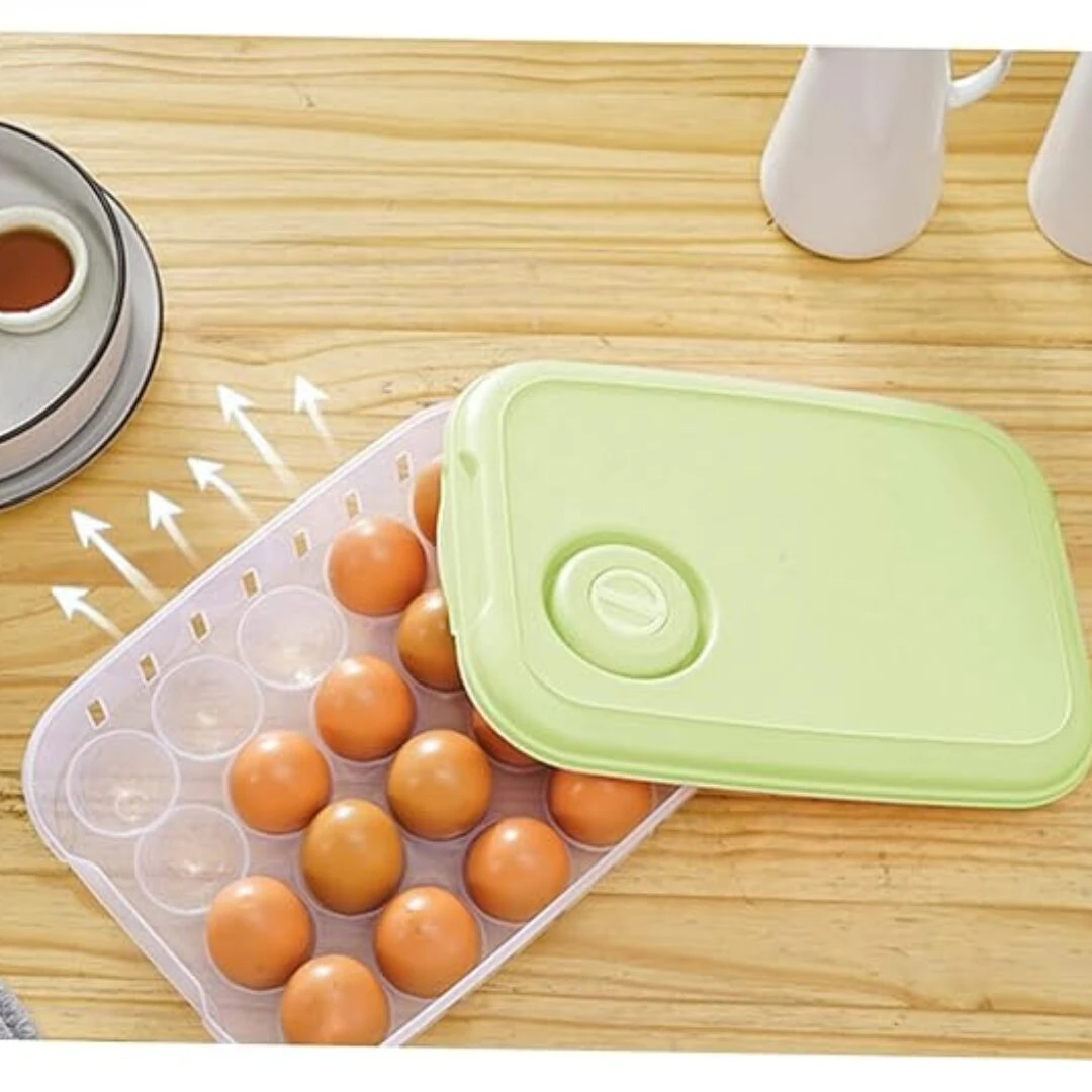 Organizador de huevos transparente para 20 unidades con tapa verde claro, sobre mesa de madera.