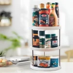 Organizador giratorio de cocina blanco de tres niveles con especias, salsas y latas en encimera.