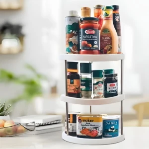 Organizador giratorio de cocina blanco de tres niveles con especias, salsas y latas en encimera.