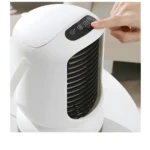 Aire acondicionado portátil blanco, detalle de control táctil con mano, ideal para refrescar espacios personales.