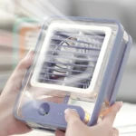 Portátil ventilador 3 en 1 morado con humidificador, persona sostiene para refrescar.