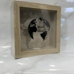 Caja de ahorro de madera clara con mapa mundial y globo terráqueo impresos.