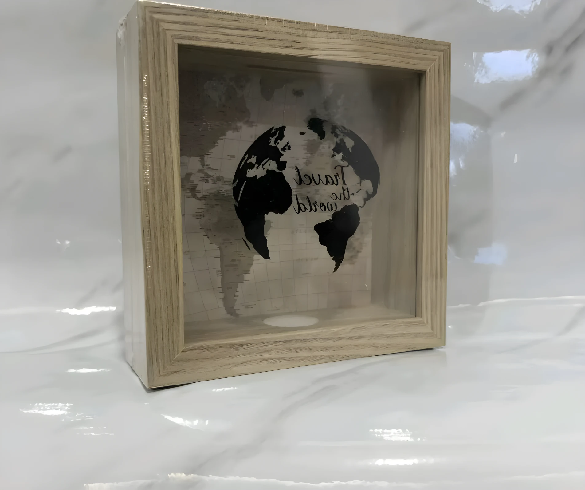 Caja de ahorro de madera clara con mapa mundial y globo terráqueo impresos.