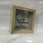 Alcancía de madera con vidrio, frase "Follow your dreams" y diseño de monumentos turísticos, perfecta para decorar y ahorrar.