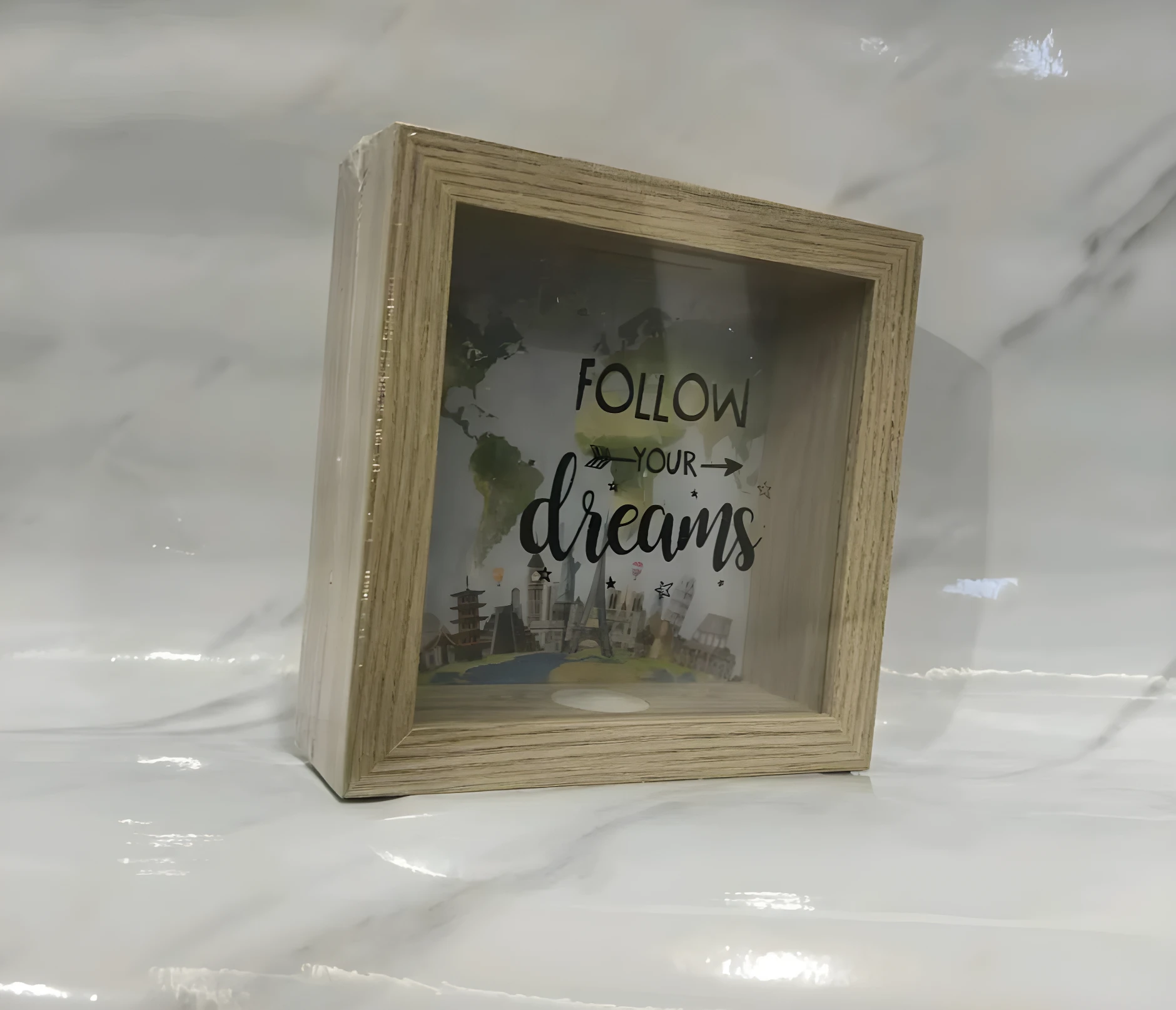 Alcancía de madera con vidrio, frase "Follow your dreams" y diseño de monumentos turísticos, perfecta para decorar y ahorrar.