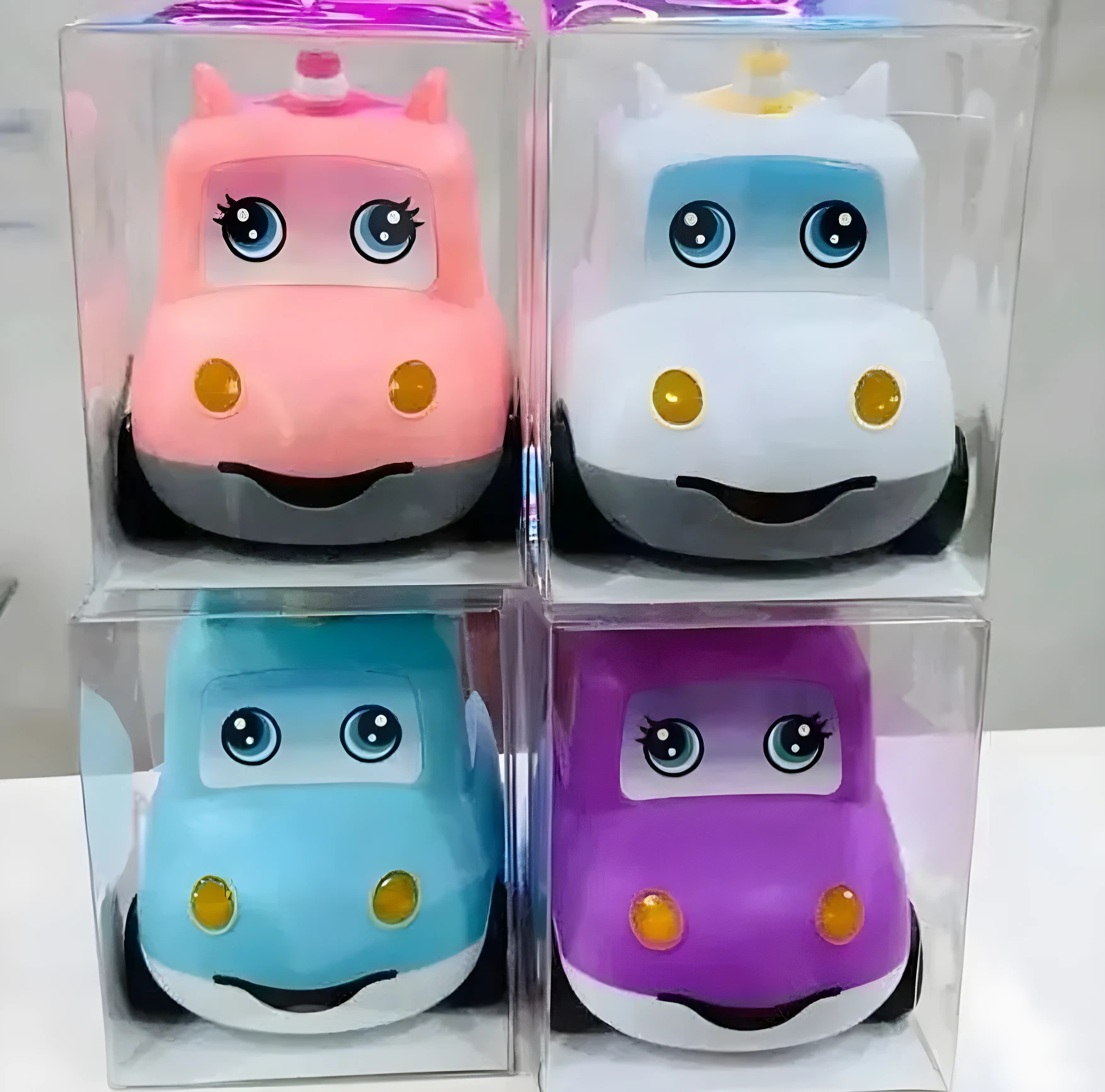 Cuatro alcancías unicornio para niñas: rosa, blanca, azul y morada, en cajas transparentes.