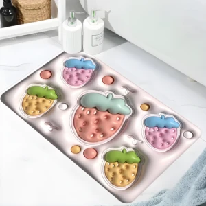 Tapete antideslizante rosa para baño con textura 3D de fresas de colores verde, amarillo, rosa y azul.
