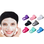Mujer con mascarilla facial sonriendo y banda negra. Se muestran siete bandas ajustables de felpa para cabello en colores: morado, rosa, blanco, negro, gris, fucsia, menta y azul.