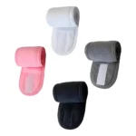Cuatro bandas sujetadoras de toalla para el cabello, colores blanco, rosa, gris y negro, enrolladas mostrando cierre de velcro.