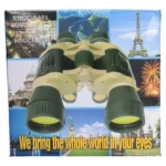 Binoculares grandes color verde oliva y beige sobre caja con monumentos mundiales y texto "We bring the whole world in your eyes".