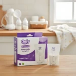 Caja blanca y morada de bolsas Only Baby para leche materna (30 unidades, 120ml) con dos bolsas de muestra al frente sobre mesa de madera.
