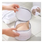 Bolsa de malla blanca para lavar sujetador, con detalle de cierre en gris. Ideal para proteger ropa delicada.