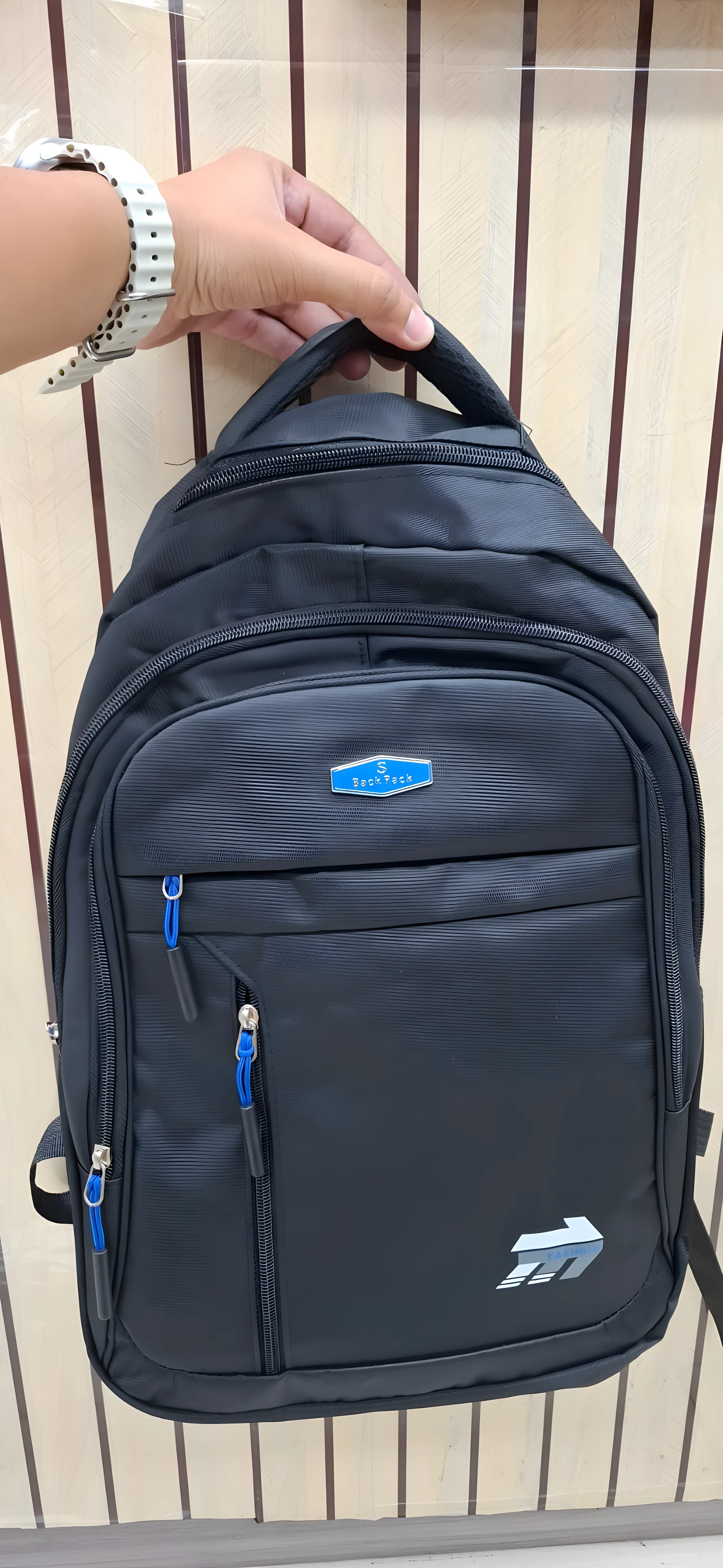 Mochila negra escolar o viajera con logo azul en relieve y detalles en azul.