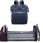 Bolso pañalera azul marino con cuna plegable portátil de color púrpura.
