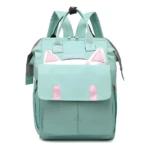 Mochila pañalera turquesa con diseño de gatito y orejas rosadas, ideal para bebés.