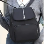 Bolso negro casual para dama, con múltiples cierres plateados y diseño moderno, ideal para uso diario.