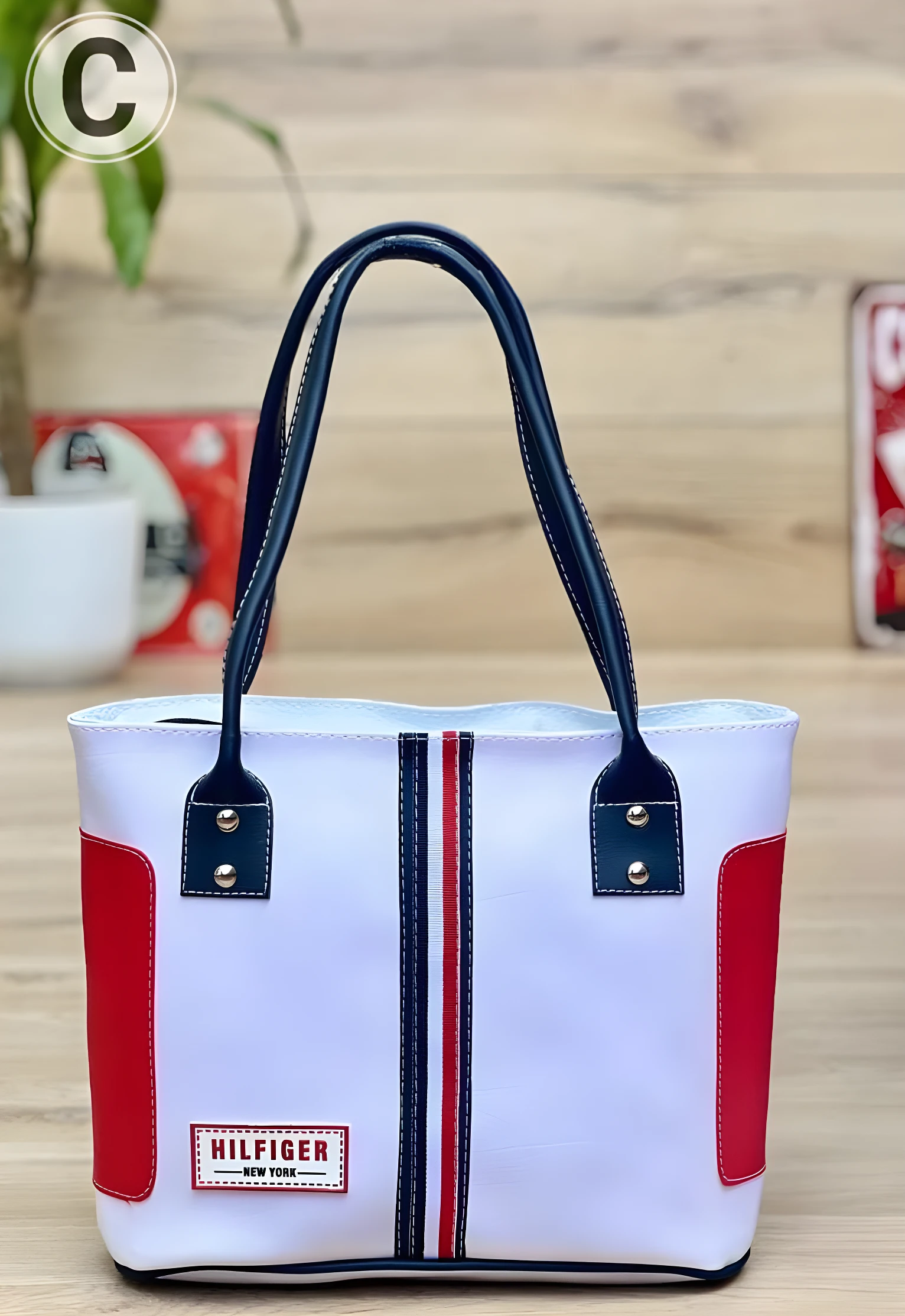 Bolso playero Tommy blanco con detalles rojos, logo "Hilfiger New York" y tirantes negros.
