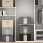 Clóset organizado con cajas organizadoras apilables para ropa, tonos beige, gris y azul, junto a prendas colgadas.