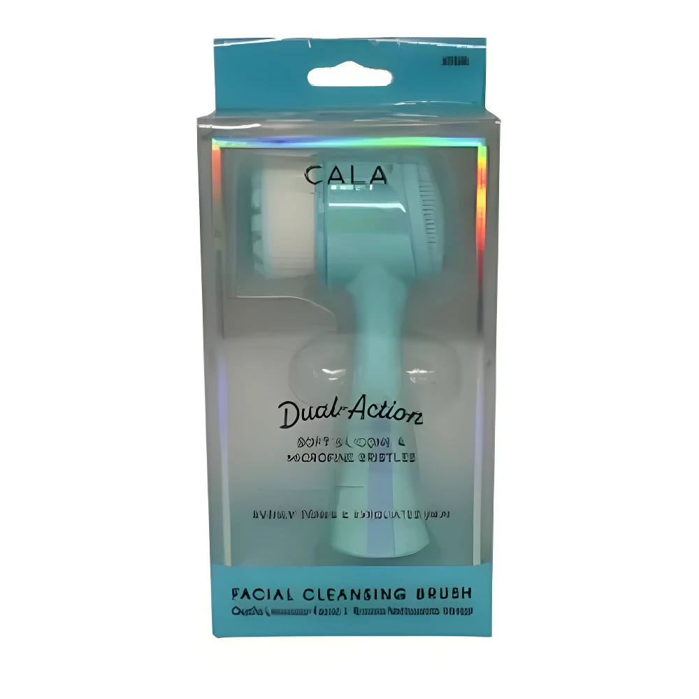 Cepillo facial Cala Dual-Action turquesa en empaque holográfico, con cerdas suaves para limpieza y exfoliación.