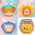 Cuatro calzones entrenadores de bebé con diseños de animales: perro, león sonriente y león guiñando, ideales para transición de pañal.