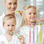 Madre sonriente ayuda a dos niños rubios a usar cepillos de dientes de tres caras en colores rosa, verde y amarillo.