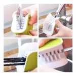 Cepillo limpiador verde y blanco para cubiertos, con ranuras para lavar eficientemente.