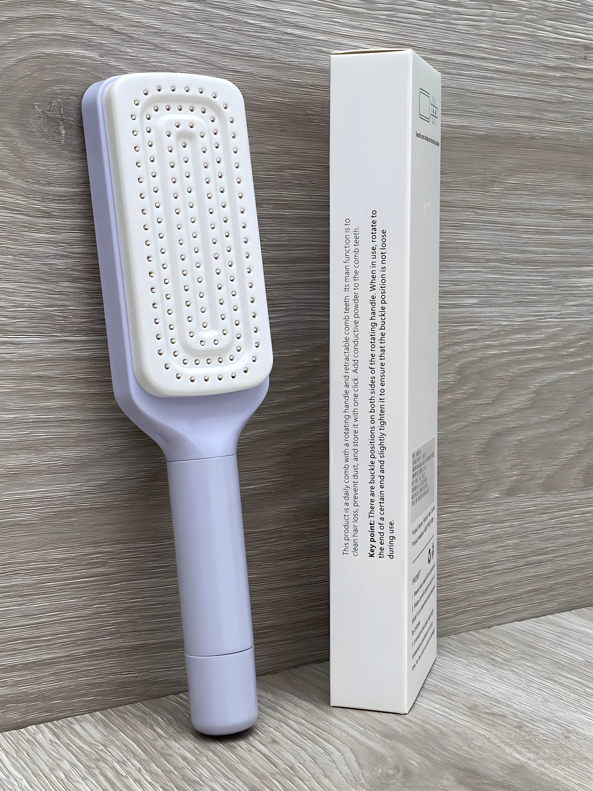 Cepillo peine retráctil lavanda con cerdas blancas para limpieza automática de cabello.