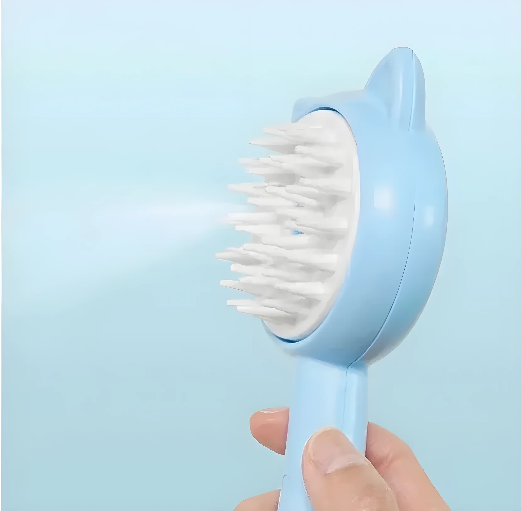 Cepillo vaporizador azul para mascotas con cerdas blancas y diseño de orejitas, activado con rocío fino.