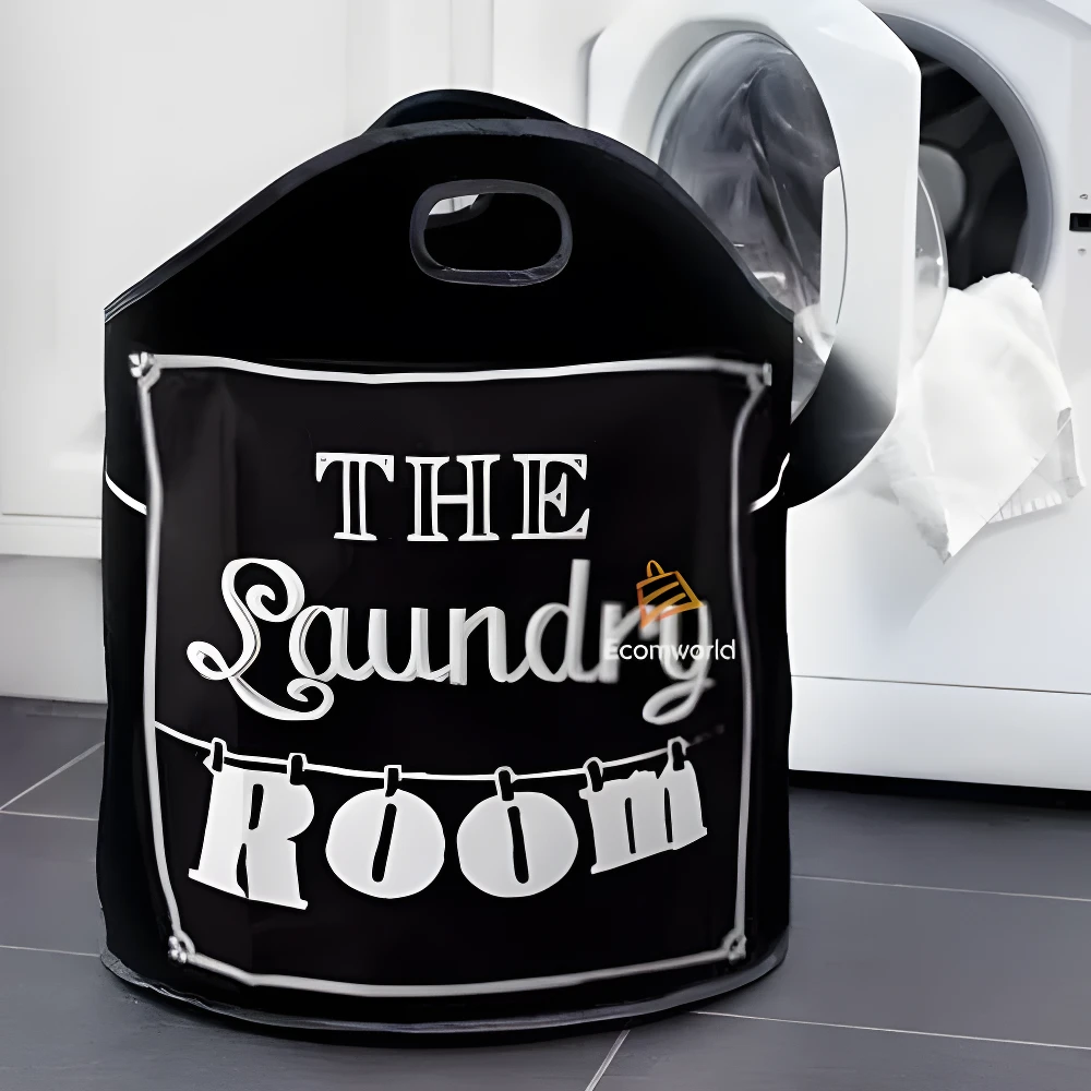 Cesta negra para ropa sucia con texto blanco "The Laundry Room", junto a lavadora.