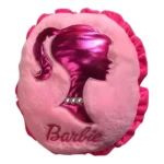 Almohada decorativa rosa con silueta Barbie metálica brillante y texto "Barbie", se despliega en cobija.