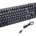 Teclado USB negro plano con cable visible y conector, visto desde arriba en diagonal.