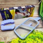 Cortador mandolina Multi-Mandoline Slicer azul claro desempacado con protector de mano púrpura sobre fondo de madera y vegetales verdes.