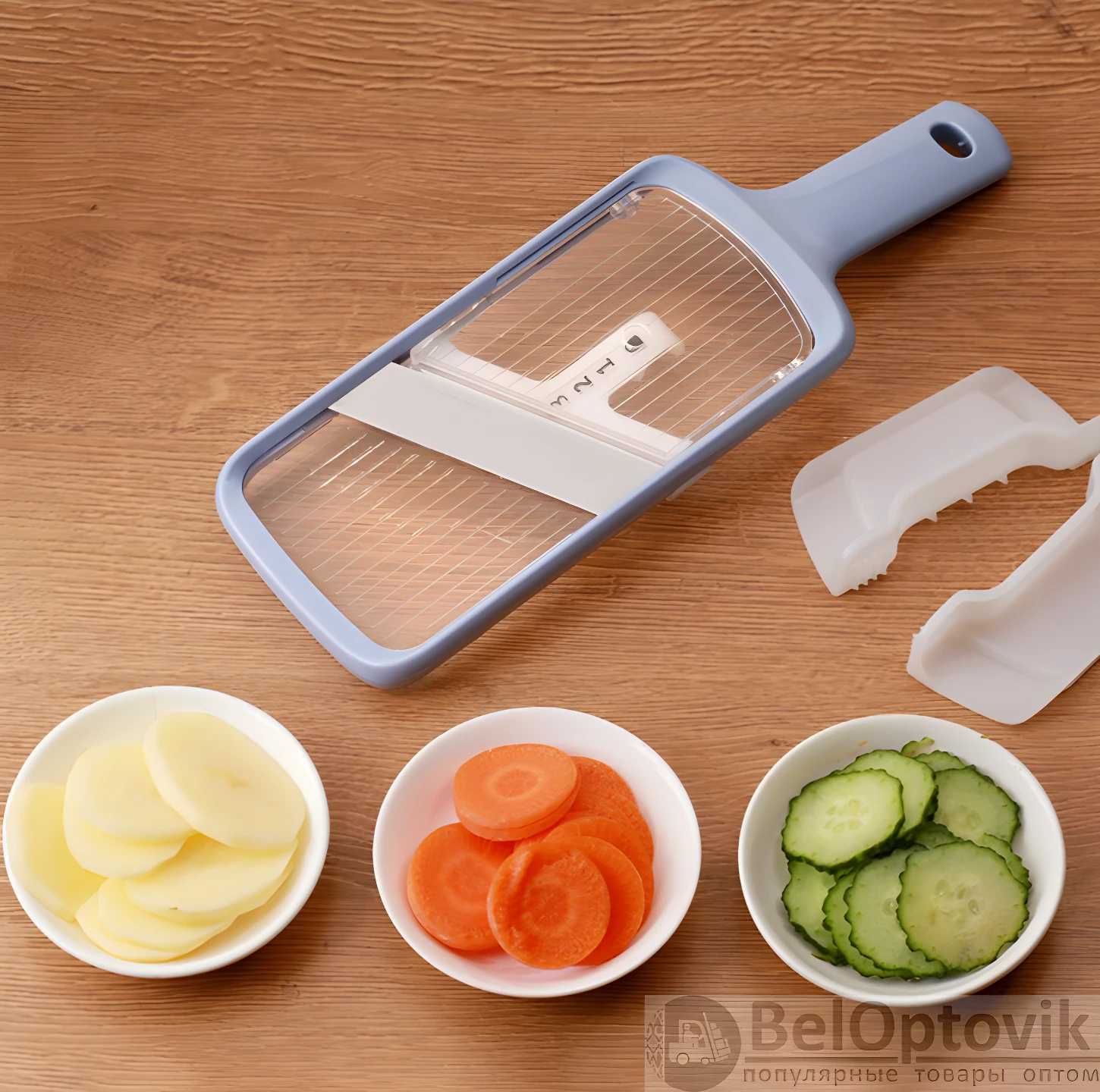 Mandolina cortadora azul con ajuste de grosor (1-3) y rodajas de papa, zanahoria y pepino en cuencos.