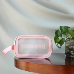 Cosmetiquera transparente rosa con texto "WASHBAG", ideal para organizar artículos de tocador.