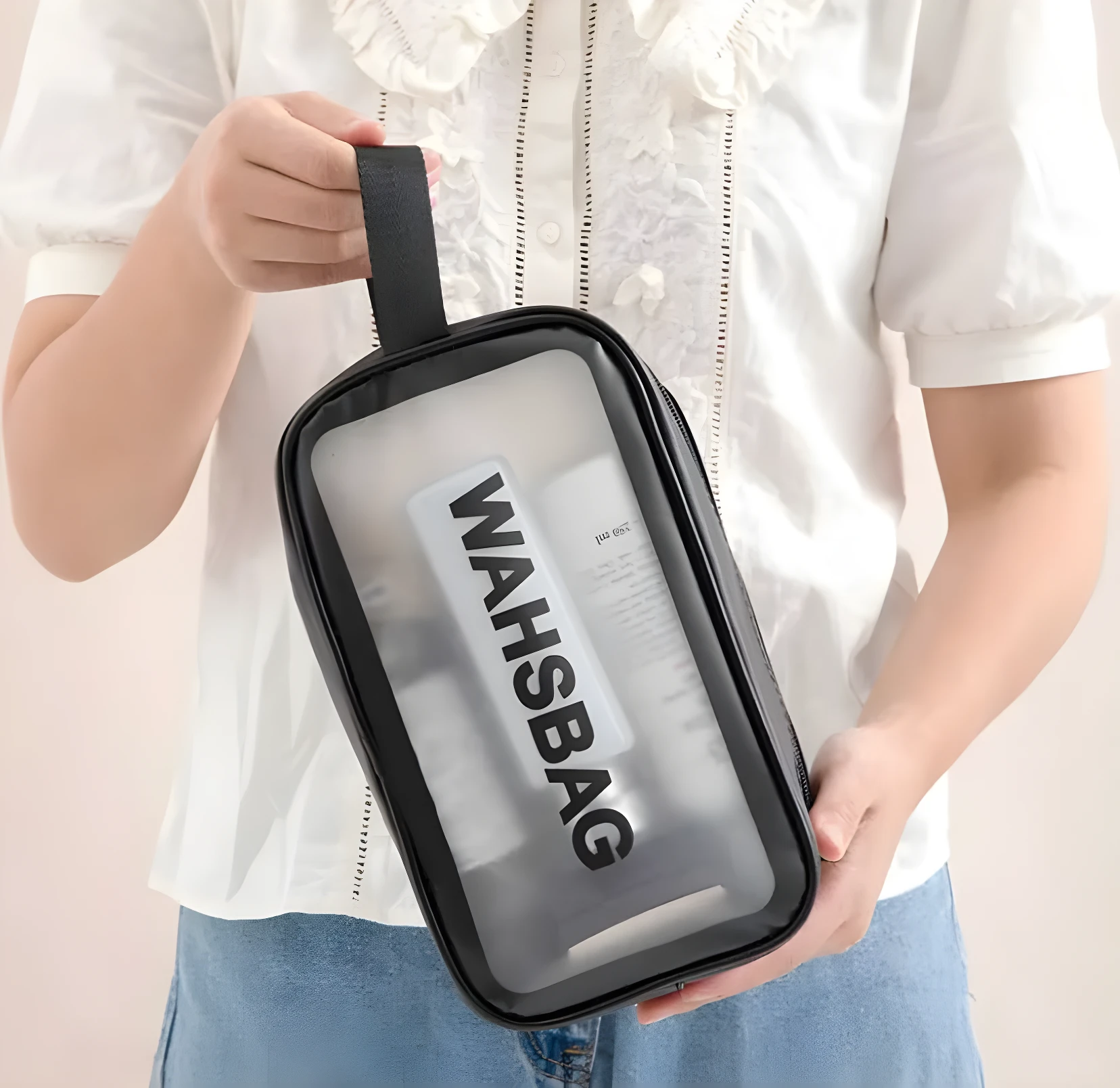 Cosmetiquera transparente negra modelo Washbag, sosteniendo varios productos.