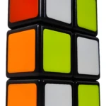 Cuboide 1x2x3 stickerless negro con caras naranja, blanco y verde lima, visto en ángulo picado.