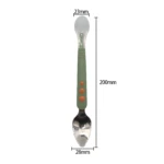 Cuchara doble cabeza 200mm: un extremo silicona para bebé, otro metal con borde para rallar fruta. Mango verde con puntos naranja.